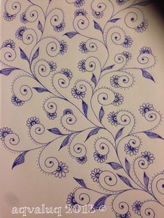 an intricate drawing on paper with blue flowers and swirls in the center is shown