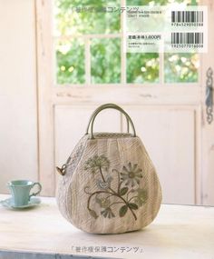 a handbag sitting on top of a table next to a cup and saucer