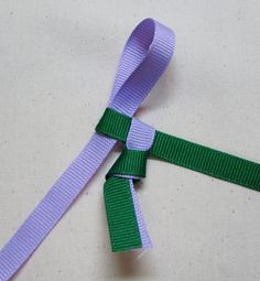 two purple and green ribbons tied to each other