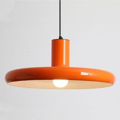 an orange pendant light hanging from a ceiling