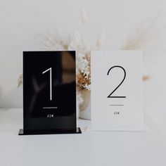 two black and white table numbers sitting next to each other