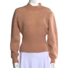 a female mannequin wearing a tan sweater and white skirt