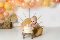 a baby sitting in front of a cake