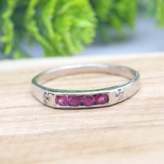 a close up of a ring on a wooden surface with leaves in the back ground