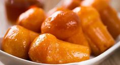 a bowl filled with oranges sitting on top of a table