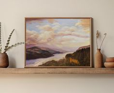 a painting is hanging on the wall above a shelf