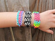 a woman's arm with four different colored bracelets on top of each other