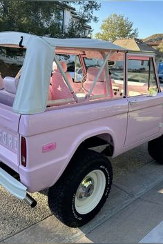 a pink pick up truck parked on the street