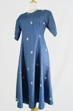 Vintage handmade denim floral embroidered dress.  Short sleeves with delightful floral embroidery. Zips in the back. Approximate measurements (garment laying flat):Bust - 18"Shoulder to shoulder - 17.25"Waist - 30"Length (from shoulder seam to hem) - 44"*Please note that most vintage items have some wear due to their age. We will try our best to describe anything more than the usual wear and tear in the item description. Please feel free to email us if you have any questions.This is not your sty Embroidered Fitted Denim Dress, Fitted Vintage Embroidered Dress With Floral Embroidery, Blue Cotton Dress With Floral Applique, Vintage Cotton Embroidered Dress For Spring, Vintage Cotton Dress With Floral Embroidery, Spring Vintage Cotton Embroidered Dress, Floral Embroidered Fitted Denim Dress, Spring Cotton Embroidered Dress With Floral Applique, Vintage Cotton Embroidered Dress With Floral Embroidery