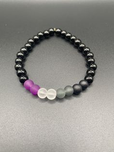 An asexual pride flag stretch bracelet with white jade or black onyx. Asexual Black Ring, Asexual Pride, Black Ring, White Jade, Pride Flag, Pride Flags, Black Rings, Stretch Bracelet, Stretch Bracelets