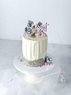 a white cake with pink and silver decorations