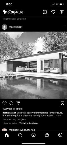 a black and white photo of a house next to a pool with trees in the background