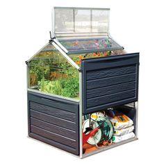 an outdoor greenhouse with plants growing in it's bottom shelf and the roof open