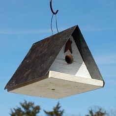 a birdhouse hanging upside down on a pole