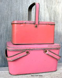 two pink suitcases sitting next to each other on top of a wooden table,