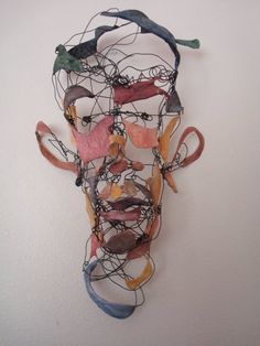 a sculpture made out of wire with birds perched on it's head and wires attached to the face