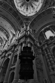 the inside of a building with columns and a clock on it's face in black and white