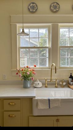 a kitchen with two windows and a sink in the center, along with dishes on the counter