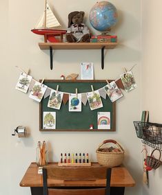 there is a desk with some pictures on it and a small boat hanging from the wall