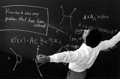 a man writing on a blackboard with white chalk and some type of formula written on it