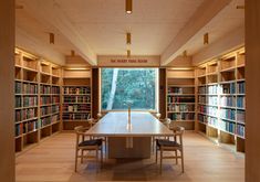 a long table in the middle of a room with many bookshelves on both sides