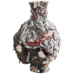 a vase that has been covered in dirt and other things on the surface, including paint