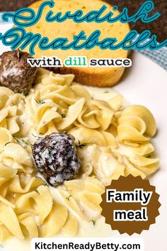 a white plate topped with pasta and meatballs next to bread on top of a table