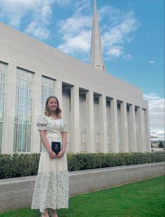 a woman standing in front of a building with a book on it's lap