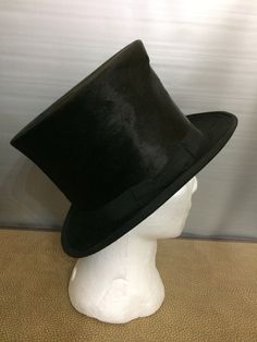 Silk Fur Top Hat The outside is a shiny silk plush, the brim edge is edged with a grosgrain ribbon trim. Internal band in natural-colored leather, lined in ivory moiré silk. The internal silk is damaged by time (as shown in the photo) The outside of the hat is in excellent condition. This top hat often called the "Silk Top Hat" because of its beautiful black color and amazing shine! Made in London, Victorian period, late 19th century, early 1900s Measurements in photo Fur Top, Victorian Period, Wool Top, Colored Leather, Ribbon Trim, Hat Making, Top Hat, Silk Top, Black Wool