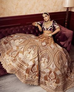 a woman sitting on top of a couch wearing a dress