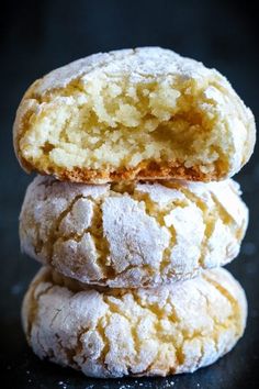 three powdered sugar cookies stacked on top of each other with one bite taken out