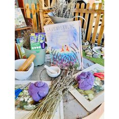 a table topped with pictures and flowers on top of a wooden table covered in dirt