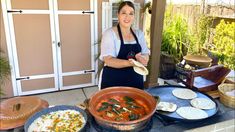 a woman standing in front of a table filled with food