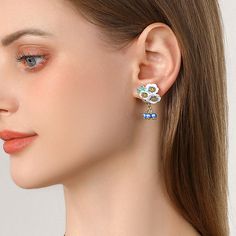 Transport yourself to a sun-drenched meadow with the enchanting Enamel Flower Blueberry Earrings. These blueberry earrings capture the essence of summer, featuring delicate enamel blooms in the vibrant hues of ripe blueberries . Accented with gleaming 18K gold-plated brass , each earring is a miniature work of art . More than just an accessory, these blueberry flower earrings are a whimsical escape. Imagine yourself strolling through a field of wildflowers, the sweet scent of berries filling the Elegant Blue Flower Charm Earrings, Elegant Blue Pierced Flower Earrings, Elegant Blue Flower Drop Earrings, Blueberry Flower, Blueberry Earrings, Summer Magic, Field Of Wildflowers, Sweet Scents, Enamel Flower