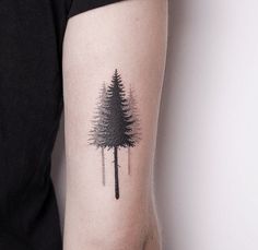 a small pine tree tattoo on the arm