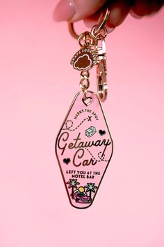 a person holding onto a keychain with the words getaway car on it