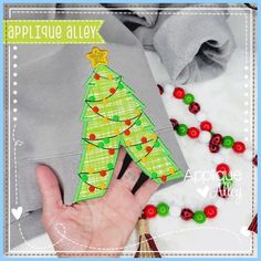 a hand is holding an applique christmas tree