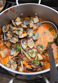 a pot filled with clams on top of a stove