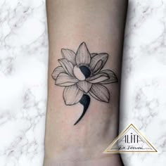 a black and white flower tattoo on the ankle