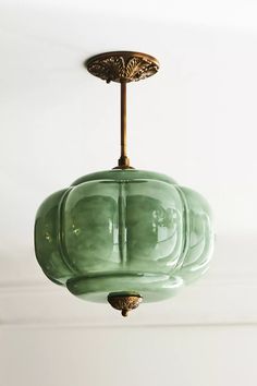 a green glass light fixture hanging from a ceiling