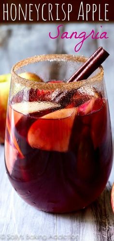 an apple sangria is served in a glass with cinnamon stick and sliced apples on the side