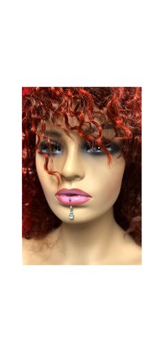 a mannequin's head with red hair and piercings on top of it