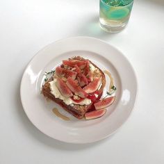 a white plate topped with toast and watermelon slices next to a glass of water