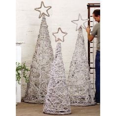 two small christmas trees made out of wire and star shaped decorations, one is standing next to the other