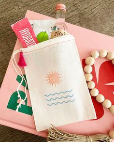 a pink tray topped with a bag filled with items