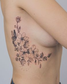 a woman's breast with flowers and butterflies on her side, as if it were done in black ink