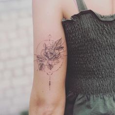 a woman's arm with a flower tattoo on the left side of her arm