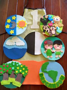 a table topped with paper plates covered in different types of decorations on top of a wooden floor