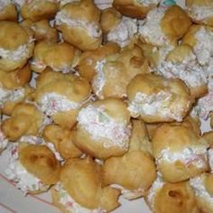 a plate full of doughnuts that are covered in powdered sugar