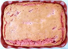 a square cake in a red dish on a white table